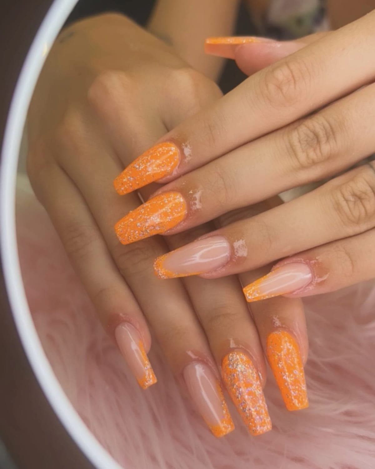 Uñas XL cuadradas alternando naranja con purpurina y nude translúcido